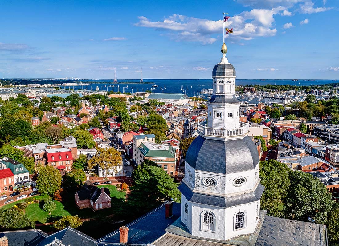 Annapolis, MD - View of the Annapolis Maryland Capitol Building in the Downtown Area with Other Businesses and Homes Surrounded by Green Trees