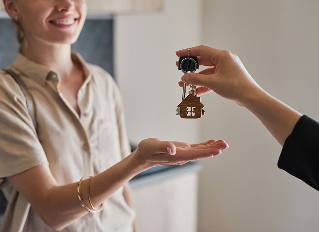 Key Tag Program - View of an Agent Handing a Smiling Young Woman her New House Keys